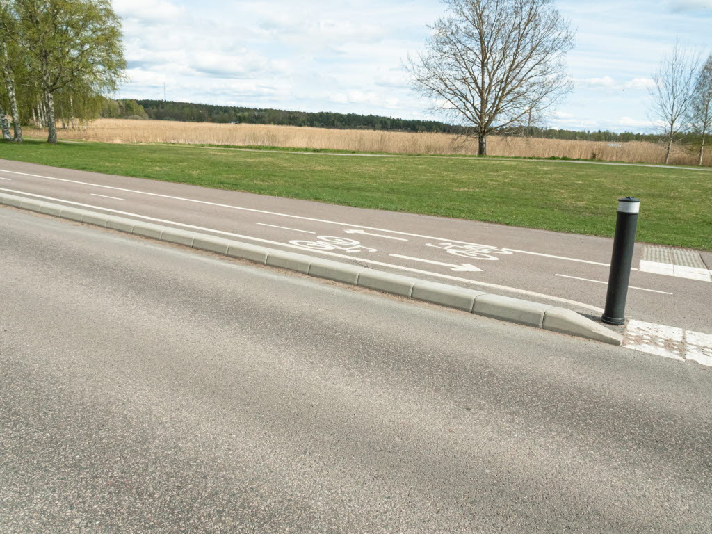 GCM-stöd ramar in cykelledens sträckning jämte fordonsvägen, med avslutning för övergångsställe.