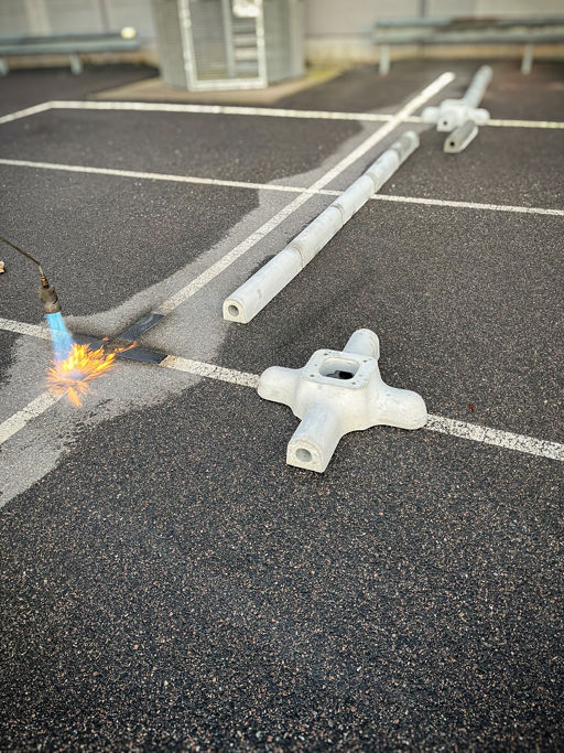 Montering av Waybler kabelstenar. Ytan förvärms med gasol och värmen aktiverar limmet och fäster stenen på plats