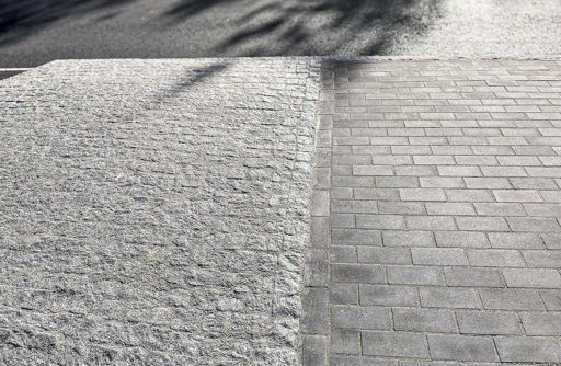 Smågatstenar och grå munksten satta i trafikmiljö;fogade med Romex D2000.