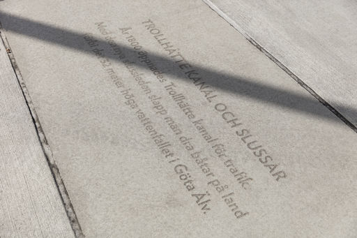 Stora betongplattor med text i som bildar en gångväg.