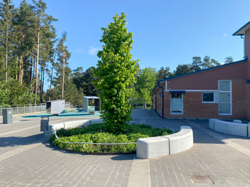 Skolgård med Outline formad runt en grön plantering