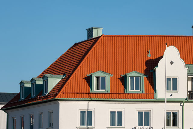 Lertegeltak i färgen naturröd och produkten Melodie. Lerteglet är lagt på Grand Hotel i Falkenberg och i bakgrunden syns grönska och hus.