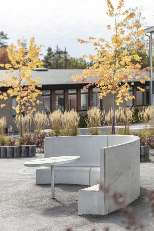 Tre Ulriksdals parksoffor ståendes i halvbåge i skolmiljö.