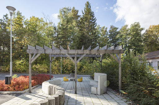 Ulriksdalssoffan i skolmiljö ståendes under en pergola.